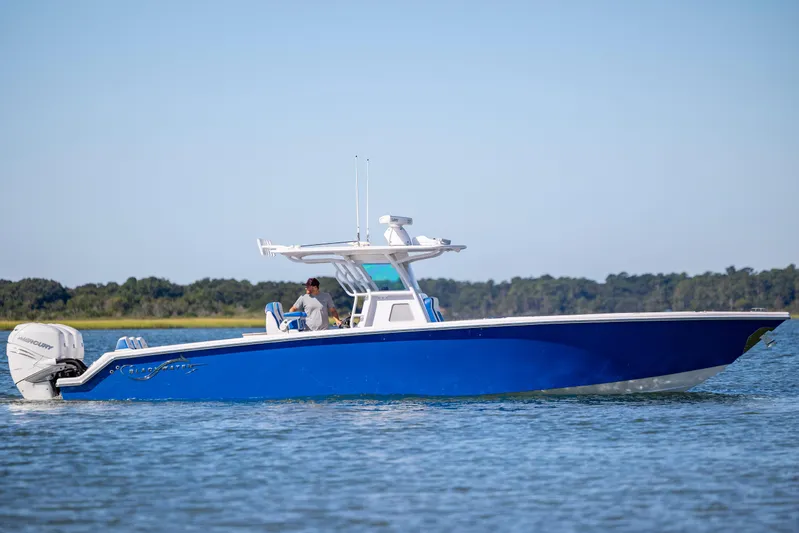  Yacht Photos Pics 2022 Blackwater 36 Sport boat cruising on calm water, featuring a sleek blue design.