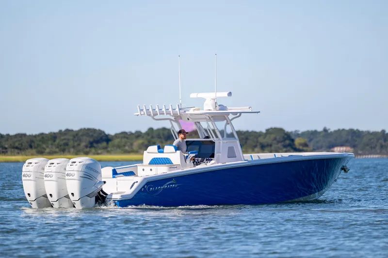  Yacht Photos Pics 2022 Blackwater 36 Sport boat cruising on a calm lake with triple outboard engines.