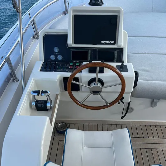  Yacht Photos Pics Helm of 2007 Apreamare 65 yacht with Raymarine navigation system and wooden steering wheel.