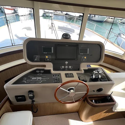  Yacht Photos Pics Helm of 2007 Apreamare 65 yacht with navigation controls and wooden steering wheel.