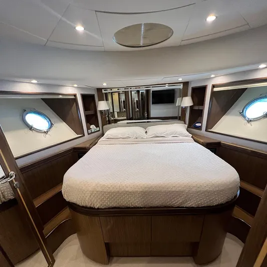 Yacht Photos Pics Luxurious bedroom interior of 2007 Apreamare 65 yacht with elegant wood finishes and porthole windows.