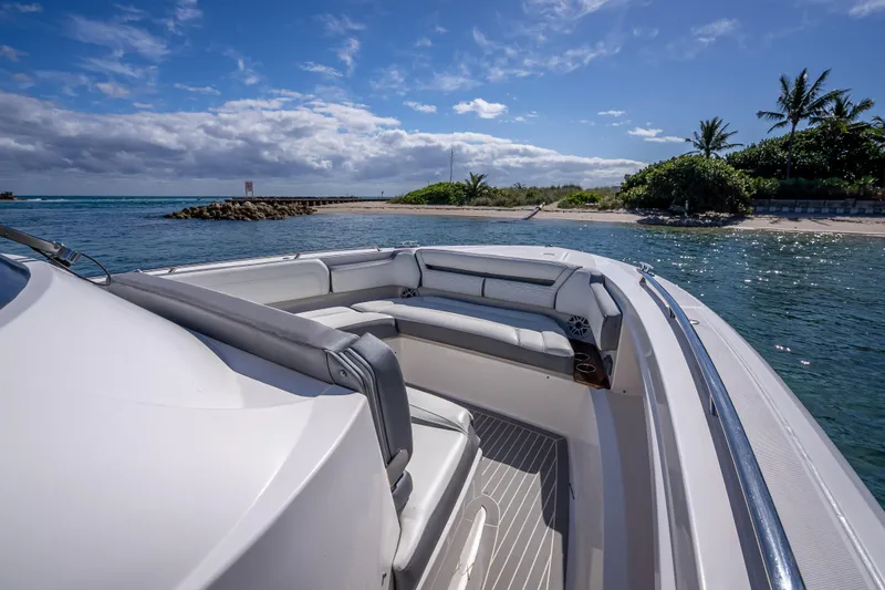 Yacht Photos Pics 2019 Tiara Sport 38 LS boat near tropical shoreline under blue sky.