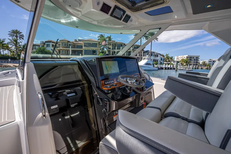  Yacht Photos Pics 2019 Tiara Sport 38 LS yacht cockpit with modern controls and waterfront view.