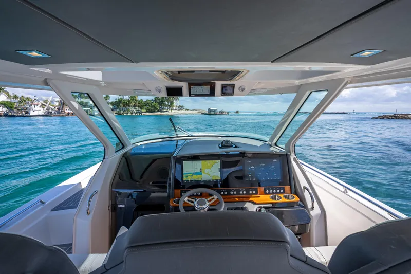  Yacht Photos Pics 2019 Tiara Sport 38 LS boat cockpit with navigation screens, steering wheel, and ocean view.