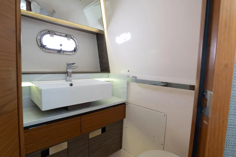  Yacht Photos Pics Luxurious bathroom interior of 2019 Tiara Sport 38 LS yacht with modern sink and porthole.