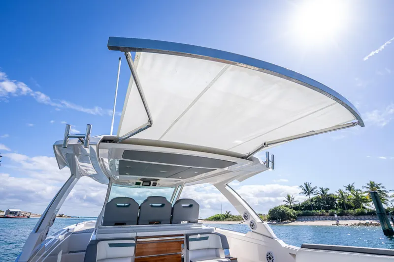  Yacht Photos Pics 2019 Tiara Sport 38 LS boat with sunshade, ocean view, and clear blue sky.
