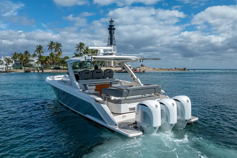  Yacht Photos Pics 2019 Tiara Sport 38 LS boat cruising near a lighthouse and palm trees.