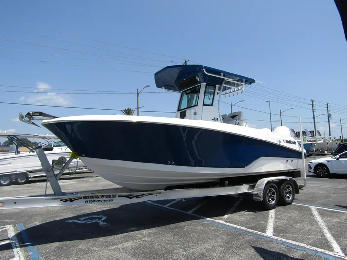  Yacht Photos Pics 2024 Wellcraft 243 Fisherman boat on a trailer in a parking lot.
