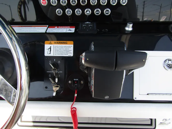  Yacht Photos Pics Control panel of 2024 Wellcraft 243 Fisherman boat with steering wheel and throttle.