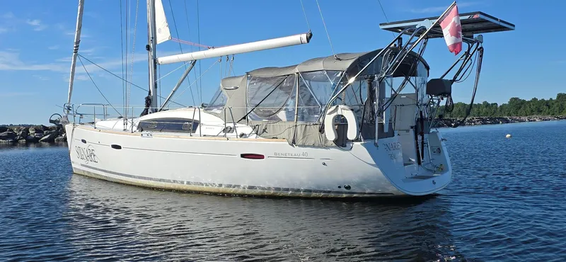 Sognare Yacht Photos Pics Beneteau Oceanis 40 sailboat, 2011 model, anchored in calm waters with a Canadian flag.