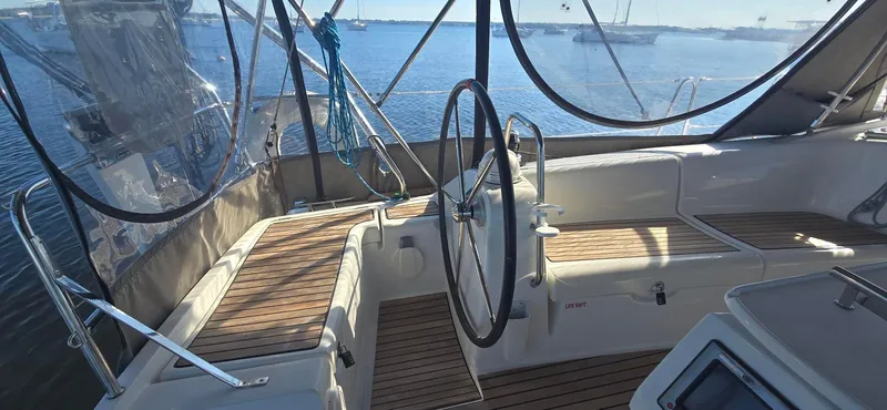 Sognare Yacht Photos Pics 2011 Beneteau Oceanis 40 cockpit with wooden seating, steering wheel, and ocean view.