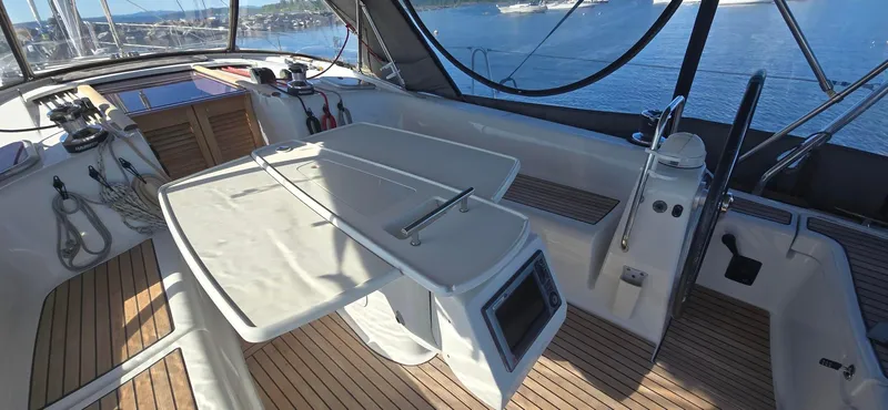 Sognare Yacht Photos Pics Spacious cockpit of 2011 Beneteau Oceanis 40 sailboat with wooden deck and navigation equipment.