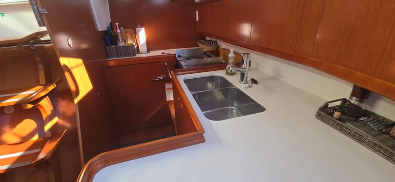 Sognare Yacht Photos Pics Interior of 2011 Beneteau Oceanis 40 yacht kitchen with wooden cabinetry and dual sink.
