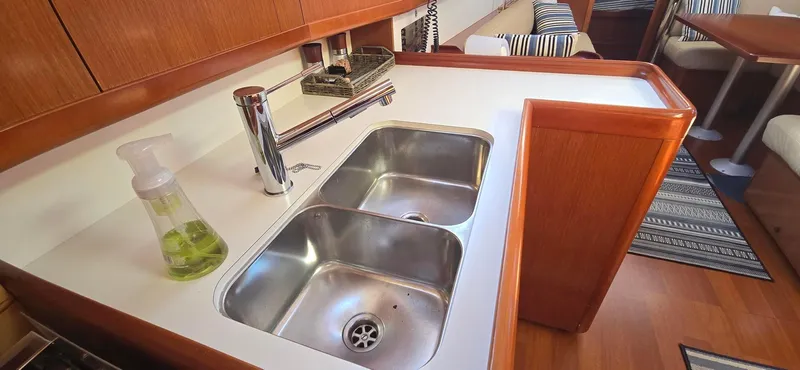 Sognare Yacht Photos Pics Beneteau Oceanis 40 yacht kitchen with double sink, soap dispenser, and wooden cabinetry, 2011 model.