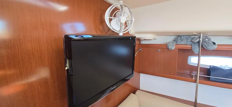 Sognare Yacht Photos Pics Interior of 2011 Beneteau Oceanis 40 with TV, fan, and plush toy on wooden paneling.