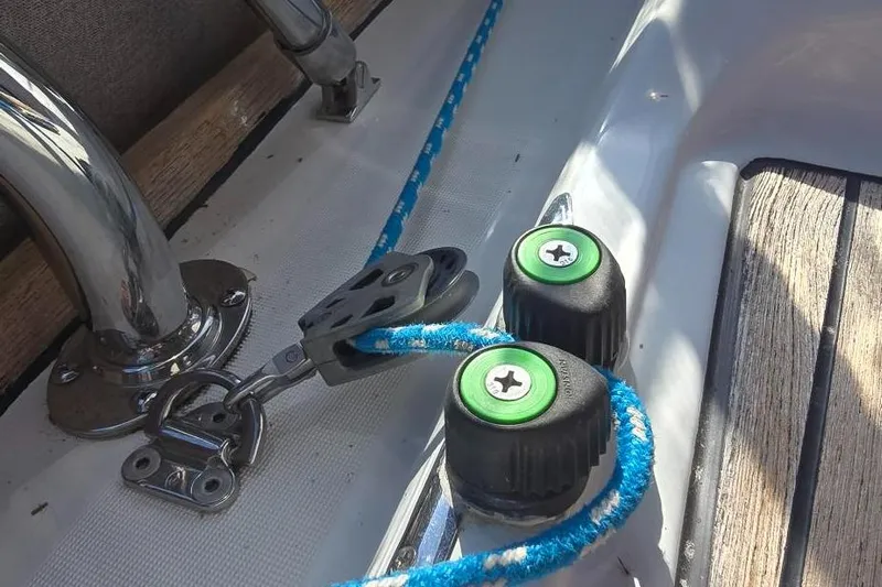Sognare Yacht Photos Pics Close-up of Beneteau Oceanis 40 sailboat deck hardware, featuring cleats and blue rope.
