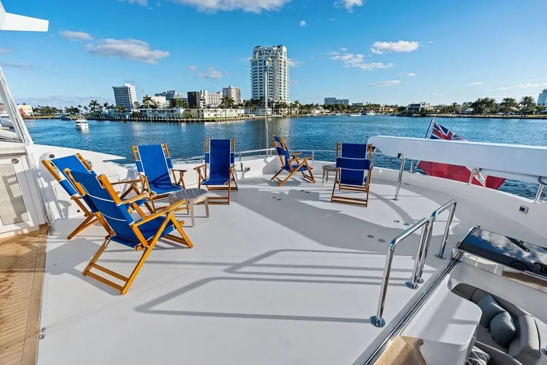  Yacht Photos Pics Spacious deck of 2014 Horizon RP 110 yacht with blue chairs, overlooking waterfront cityscape.