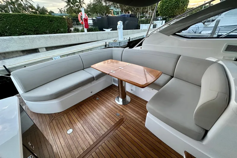 Bejul Yacht Photos Pics Luxurious seating area on 2021 Princess V40 yacht with wooden table and cushioned seats.
