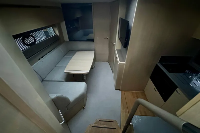 Bejul Yacht Photos Pics Interior of 2021 Princess V40 yacht with modern seating, table, and kitchenette.