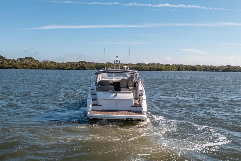 Bejul Yacht Photos Pics 2021 Princess V40 yacht cruising on a serene lake under a clear blue sky.