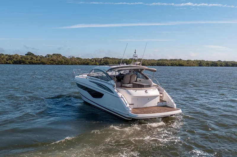 Bejul Yacht Photos Pics 2021 Princess V40 yacht cruising on a serene lake under a clear blue sky.