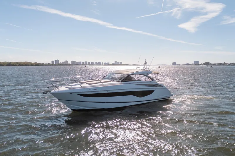 Bejul Yacht Photos Pics 2021 Princess V40 yacht cruising on a sunny day with city skyline in background.