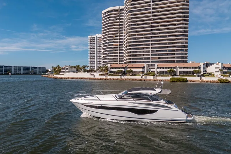 Bejul Yacht Photos Pics Luxury 2021 Princess V40 yacht cruising near waterfront high-rise buildings.