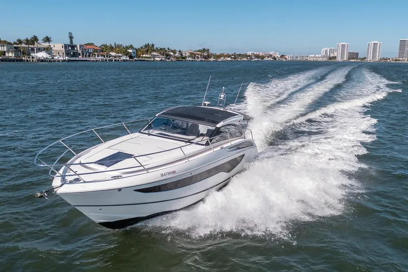 Bejul Yacht Photos Pics 2021 Princess V40 yacht cruising on a sunny day near coastal cityscape.