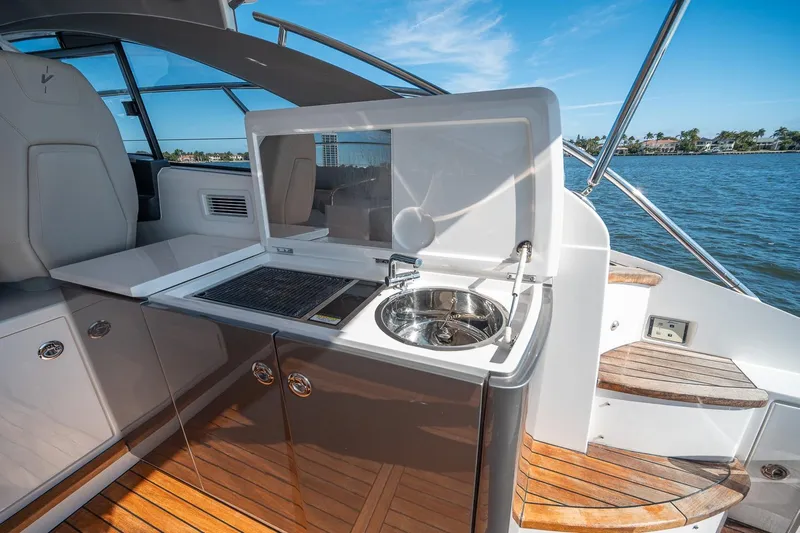 Bejul Yacht Photos Pics Outdoor kitchenette on 2021 Princess V40 yacht with sink and grill, overlooking water.