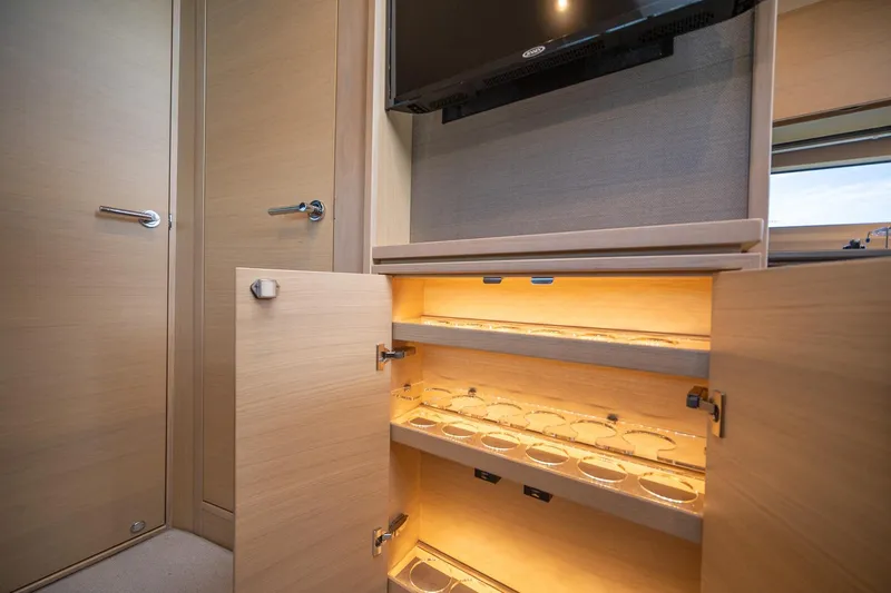 Bejul Yacht Photos Pics Interior of 2021 Princess V40 yacht with illuminated wooden storage cabinet.