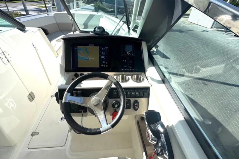 Blue Horizons II Yacht Photos Pics 2023 Boston Whaler 240 Vantage helm with steering wheel and navigation display.