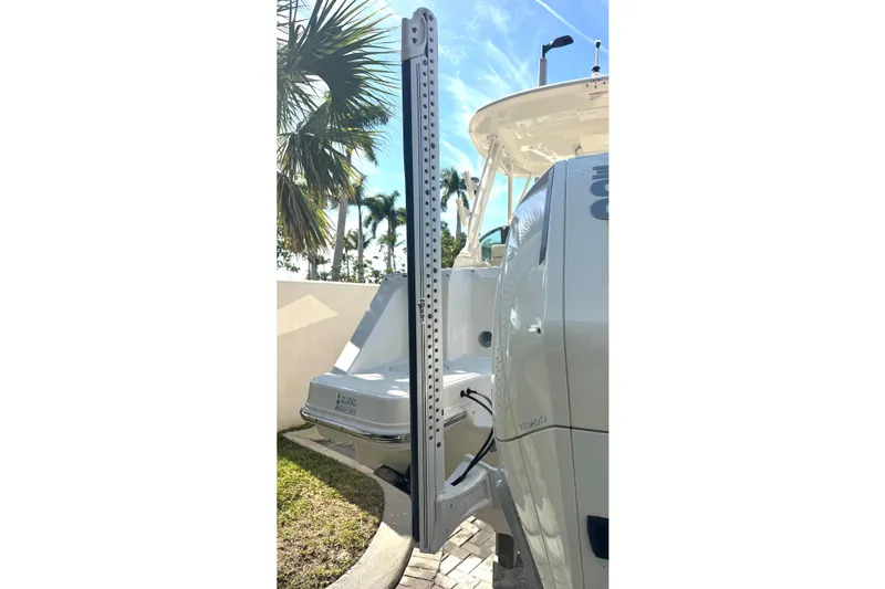 Blue Horizons II Yacht Photos Pics 2023 Boston Whaler 240 Vantage boat with outboard motor and palm trees in the background.