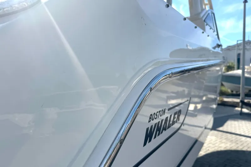 Blue Horizons II Yacht Photos Pics 2023 Boston Whaler 240 Vantage boat side view with logo in sunlight.