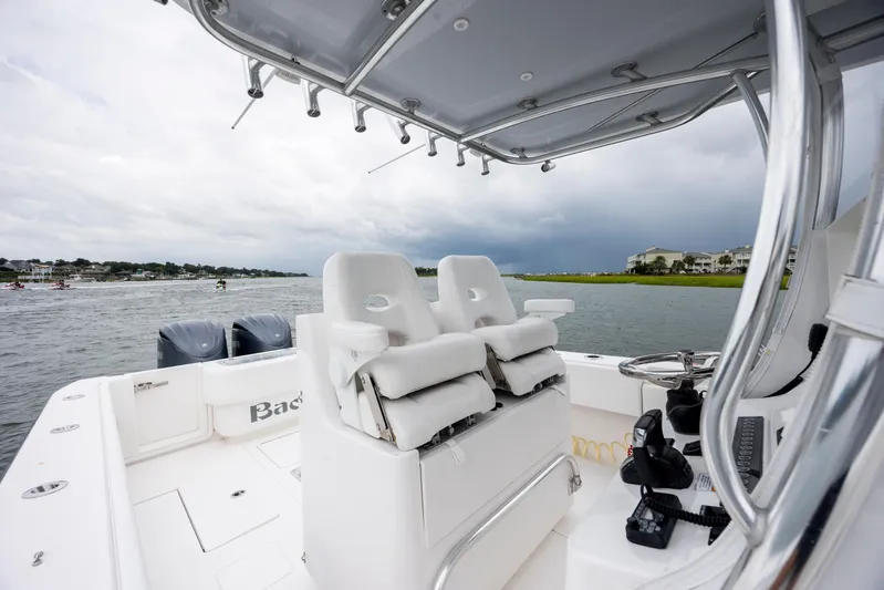  Yacht Photos Pics 2023 Contender 32 ST boat interior with dual engines on a cloudy day.