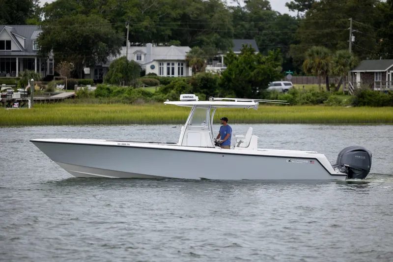  Yacht Photos Pics 2023 Contender 32 ST boat cruising on a calm river near residential area.
