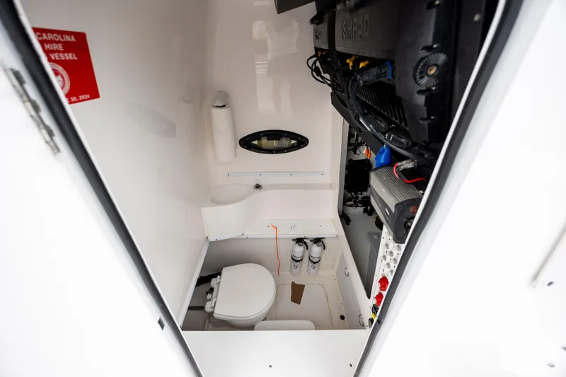  Yacht Photos Pics 2023 Contender 32 ST boat interior with toilet and equipment storage.