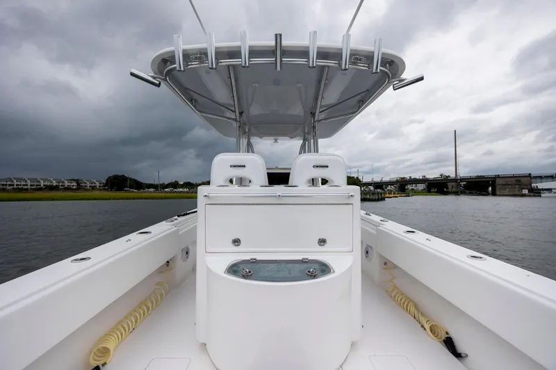  Yacht Photos Pics 2023 Contender 32 ST boat on water under cloudy sky, showcasing helm and seating area.