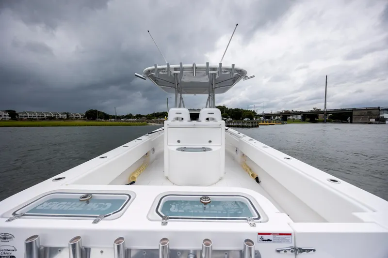  Yacht Photos Pics 2023 Contender 32 ST boat on water under cloudy sky, showcasing spacious deck.