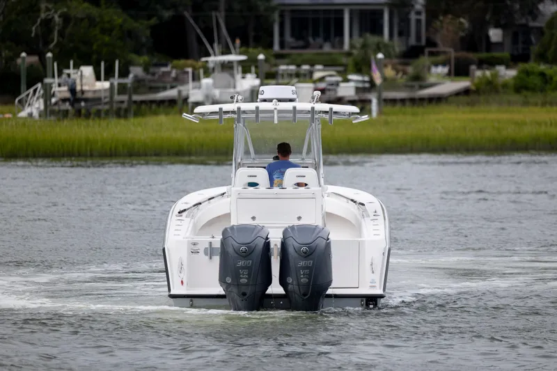  Yacht Photos Pics 2023 Contender 32 ST boat cruising on a calm river with dual engines.