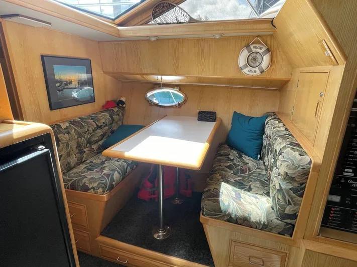  Yacht Photos Pics Cozy dining area in 1990 Ocean Alexander 440 Sundeck CPMY with floral upholstery and natural light.