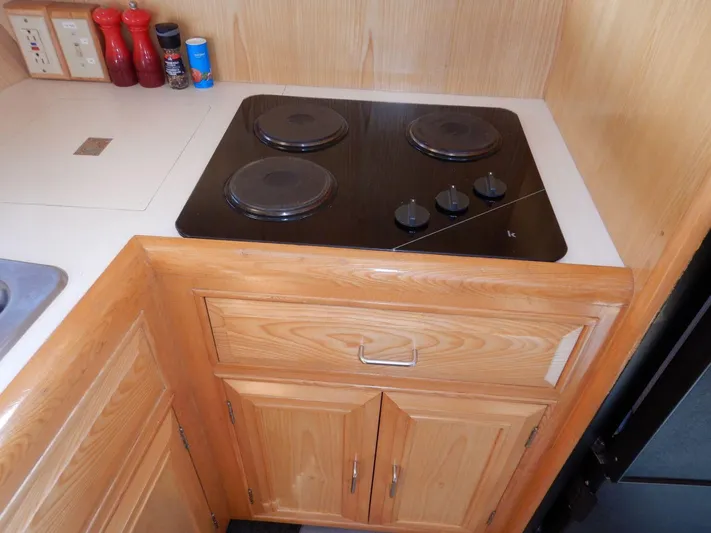  Yacht Photos Pics Kitchen area of 1990 Ocean Alexander 440 Sundeck CPMY with electric stove and wooden cabinetry.