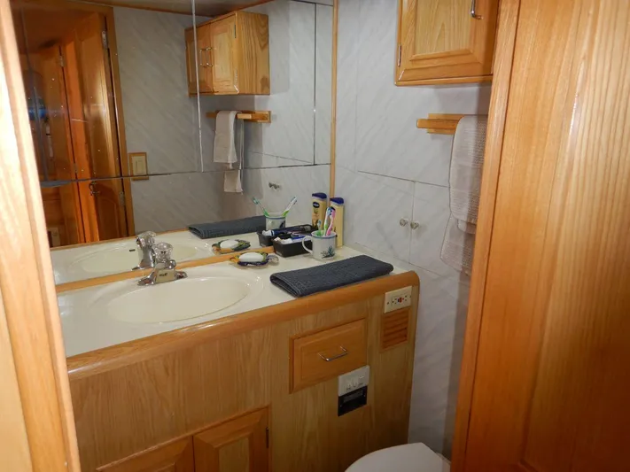  Yacht Photos Pics 1990 Ocean Alexander 440 Sundeck CPMY bathroom with wooden cabinetry and mirrored walls.