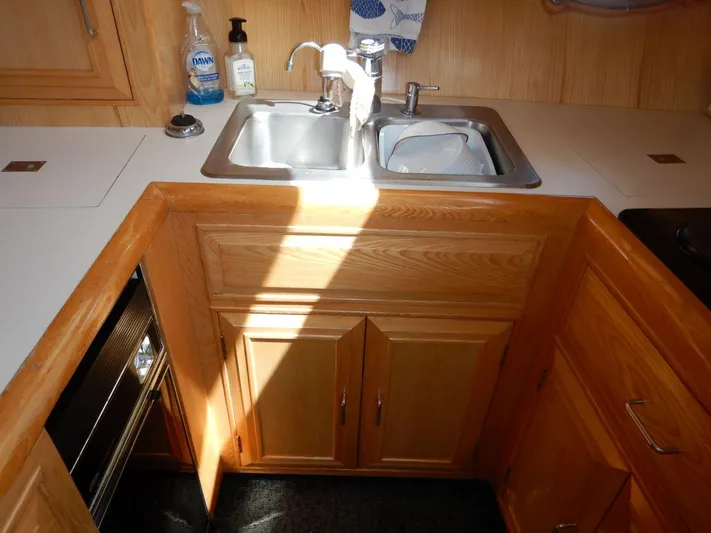  Yacht Photos Pics Kitchen area of 1990 Ocean Alexander 440 Sundeck CPMY with wooden cabinets and stainless steel sink.