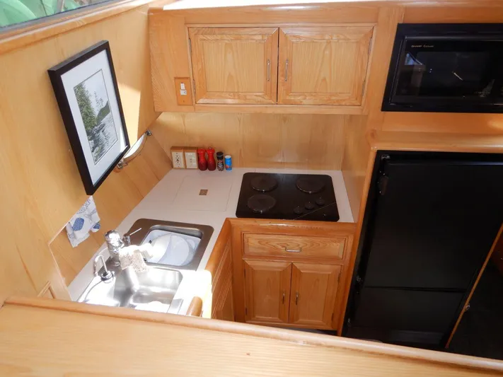  Yacht Photos Pics 1990 Ocean Alexander 440 Sundeck CPMY kitchen with wooden cabinets, stove, sink, and refrigerator.