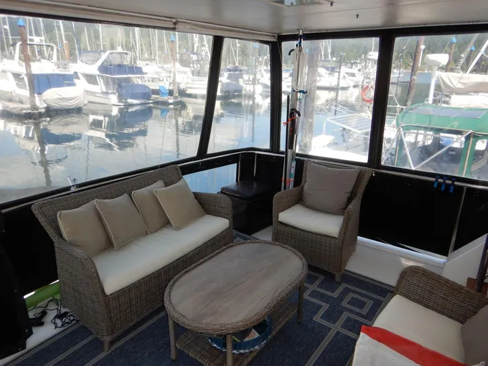  Yacht Photos Pics 1990 Ocean Alexander 440 Sundeck CPMY interior with wicker furniture and marina view.