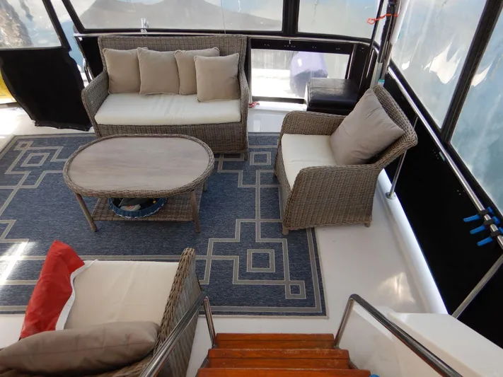  Yacht Photos Pics 1990 Ocean Alexander 440 Sundeck CPMY interior with wicker furniture and geometric rug.