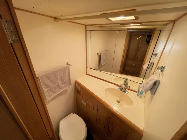 Yacht Photos Pics 1990 Ocean Alexander 440 Sundeck CPMY bathroom with sink, mirror, and toilet.