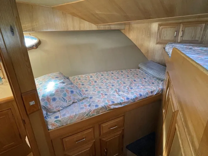  Yacht Photos Pics Cozy cabin interior of 1990 Ocean Alexander 440 Sundeck CPMY with wooden finish and bedding.