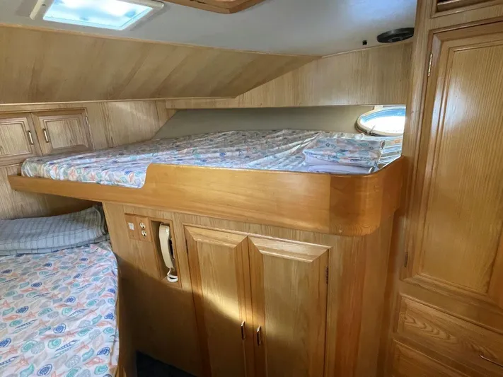  Yacht Photos Pics Interior cabin of 1990 Ocean Alexander 440 Sundeck CPMY with wooden furnishings and bedding.