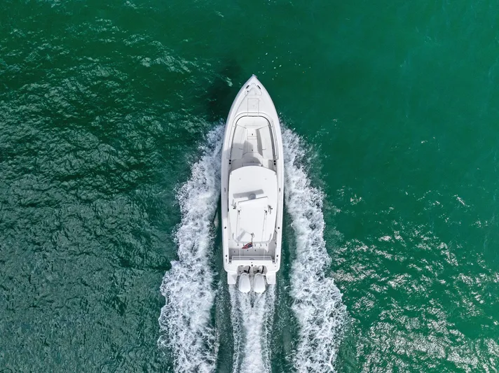 Double Trouble Yacht Photos Pics Aerial view of 2017 Intrepid 327 Center Console boat cruising on turquoise water.